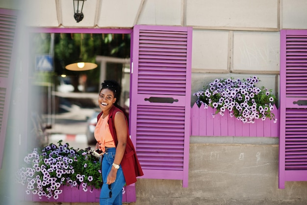 Afro-Amerikaans meisje poseerde tegen paarse ramen buiten