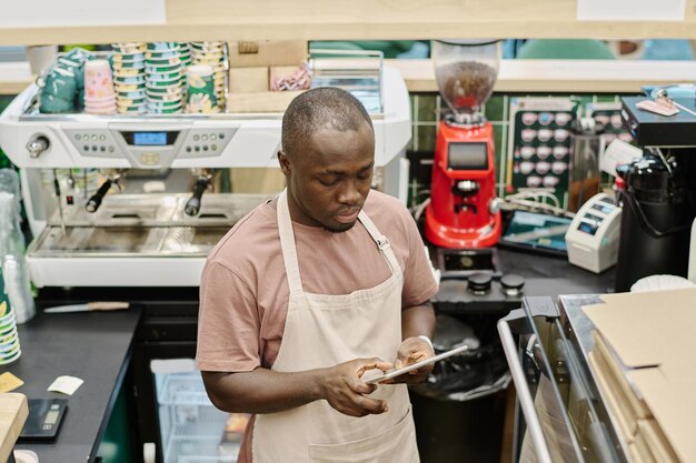 Afro-Amerikaanse barman die online werkt op digitale tablet
