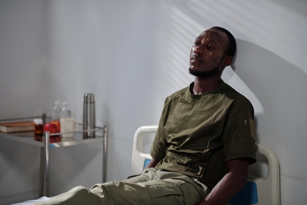 Afro-Amerikaanse depressieve soldaat liggend op bed in militair hospitaal