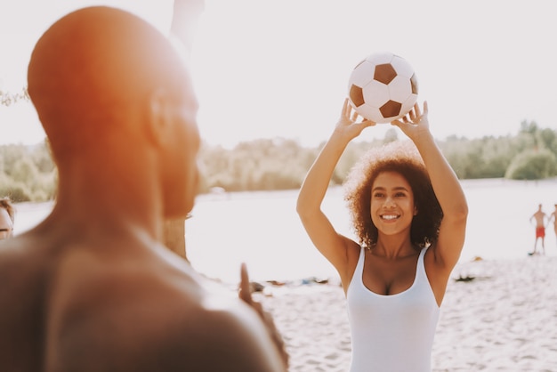 Afro-amerikaanse echtpaar spelen bal op het strand