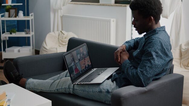 Afro-Amerikaanse etniciteit man met behulp van online conferentie webcam communicatie om verbinding te maken via internet...