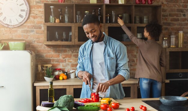 Afro-Amerikaanse familie in de keuken. Zwart koppel koken in loft interieur