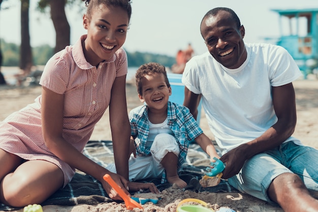 Afro-Amerikaanse familie speelt met speelgoed op Sandy Shore