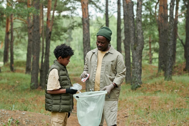 Afro-Amerikaanse familie van twee die samen bos schoonmaken van afval