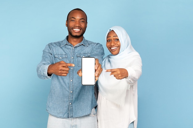 Afro-Amerikaanse islamitische paar weergegeven: telefoon leeg scherm blauwe achtergrond