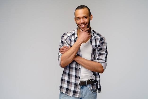 Afro-Amerikaanse jonge man met casual shirt over lichtgrijze muur