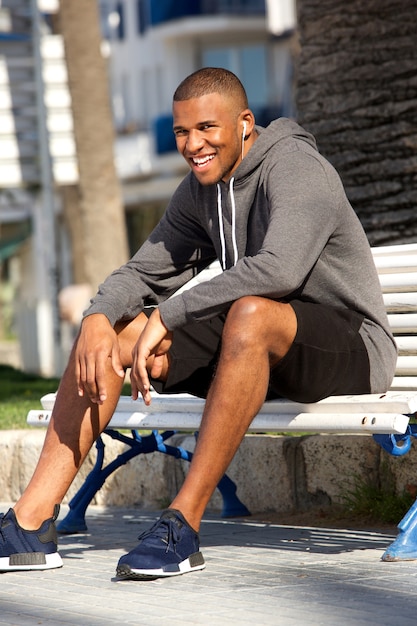 Afro-Amerikaanse jonge mannelijke loper ontspannen na fitnesstraining