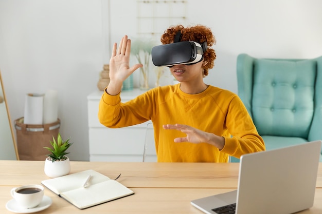 Afro-amerikaanse jonge vrouw met behulp van virtual reality metaverse vr bril headset thuis meisje