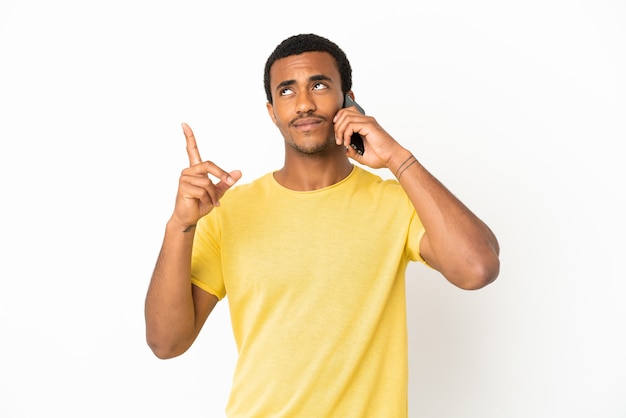 Afro-Amerikaanse knappe man met behulp van mobiele telefoon over geïsoleerde witte achtergrond die een geweldig idee benadrukt