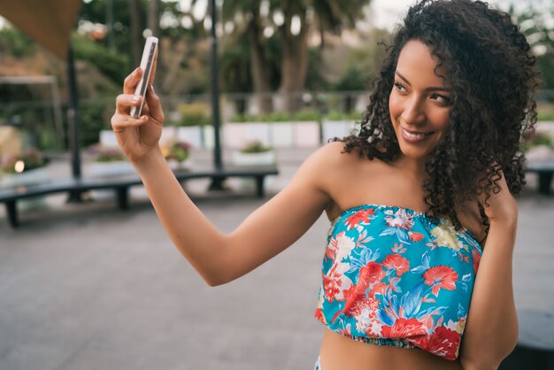 Afro-Amerikaanse Latijns-vrouw die een selfie met telefoon.