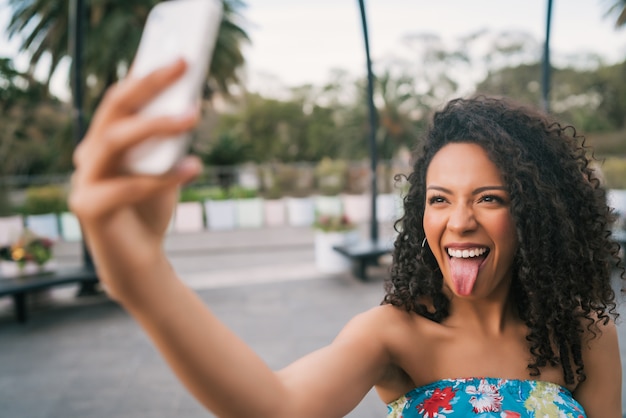 Afro-Amerikaanse Latijns-vrouw die een selfie met telefoon.