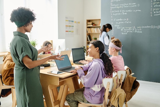 Foto afro-amerikaanse leraar legt materiaal uit aan studenten tijdens de les