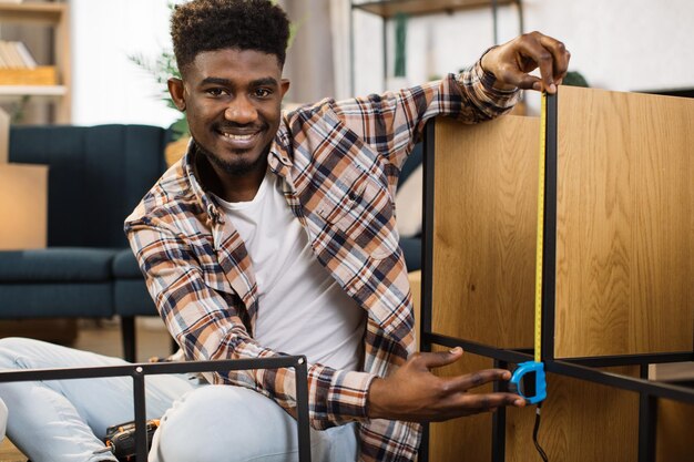 Afro-Amerikaanse man assembleert meubels in een verhuizing