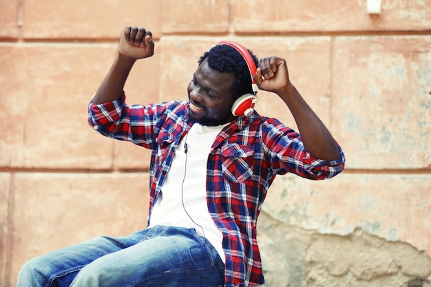 Afro-Amerikaanse man die buiten muziek luistert met een koptelefoon