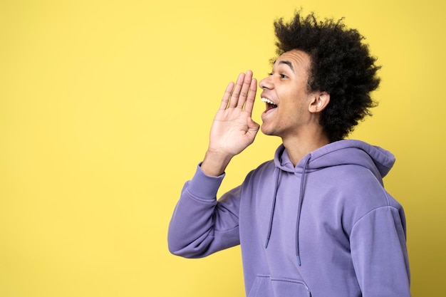 Afro-Amerikaanse man die de hand in de buurt van het gezicht houdt, luid schreeuwend geïsoleerd op de achtergrond. Winkelen