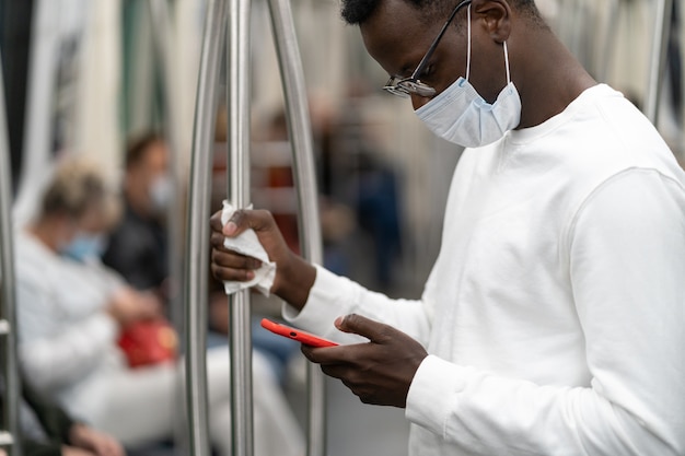 Afro-Amerikaanse man draagt gezichtsmasker in het openbaar vervoer tijdens covid pandemie