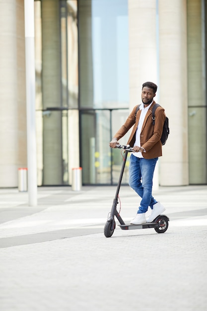 Afro-Amerikaanse Man elektrische scooter rijden in de stad