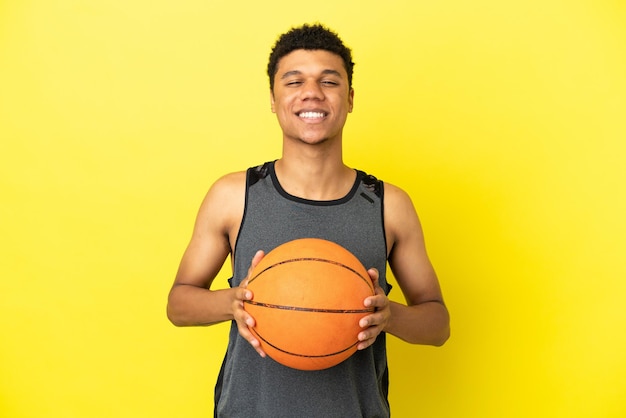 Afro-Amerikaanse man geïsoleerd op gele achtergrond basketballen