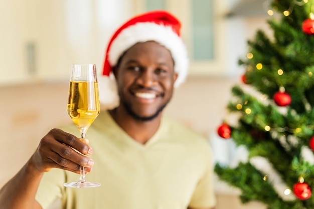 Afro-Amerikaanse man hief een glas champagne en toast thuis