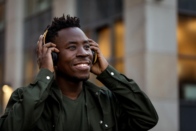 Afro-Amerikaanse man in draadloze koptelefoon luisteren naar muziek