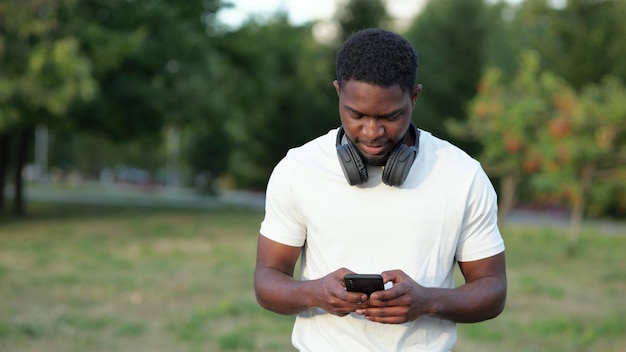 Afro-Amerikaanse man loopt berichten te typen op smartphone