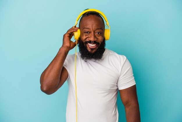 Afro-Amerikaanse man luisteren naar muziek geïsoleerd op blauwe achtergrond