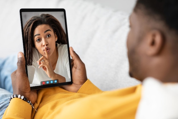 Afro-Amerikaanse man met behulp van digitale tablet die vriendin belt