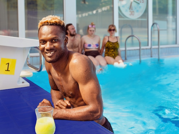 Afro-Amerikaanse man met caucaian vrienden in het zwembad zomervakantie en sport concept