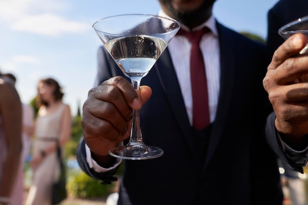 Afro-Amerikaanse man met een martini-glas in zijn handen close-up feest en vakantie concept