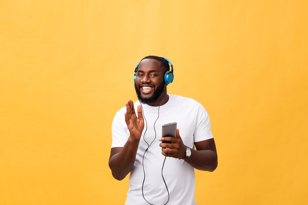 Afro-amerikaanse man met koptelefoon luisteren en dansen met muziek.