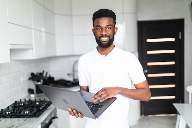 Afro-Amerikaanse man met laptop in de keuken