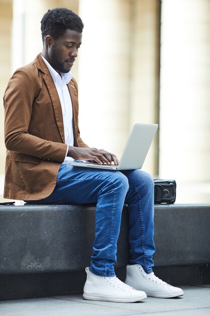 Afro-Amerikaanse man met laptop in de stad