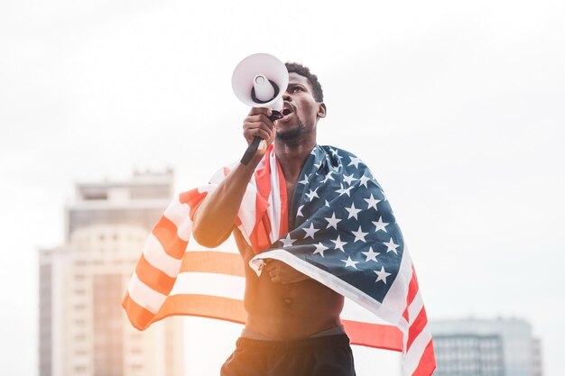 Afro-amerikaanse man met usa-vlag schreeuwend in een megafoon uit protest tegen zwarte levensmeter