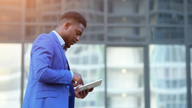 Afro-Amerikaanse man met witte tablet loopt op straat