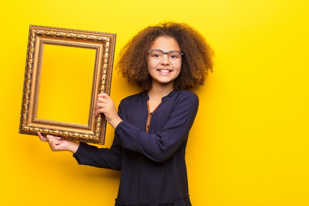 Afro-Amerikaanse meisje tegen vlakke muur met een barok frame