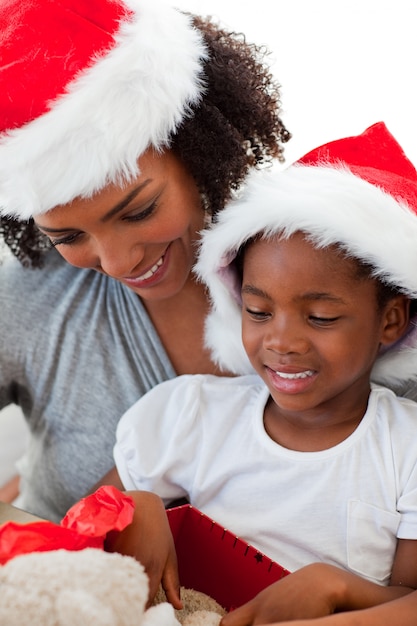 Afro-Amerikaanse moeder en dochter die een kerstcadeau openen