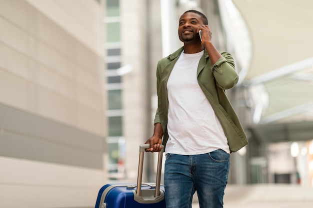 Afro-Amerikaanse reiziger die op de telefoon praat op de luchthaven