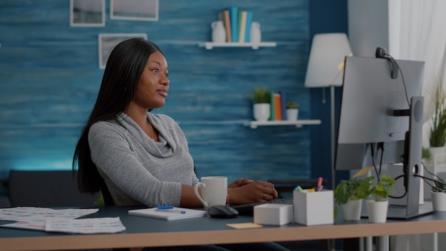 Afro-Amerikaanse student zwaait professor tijdens virtuele videocall-conferentievergadering