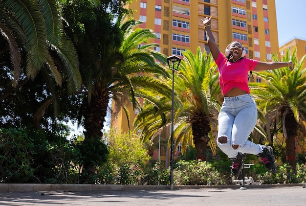 Afro-Amerikaanse tienermeisje springen met rolschaatsen