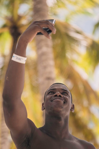 Afro-Amerikaanse toerist die selfie op het strand neemt