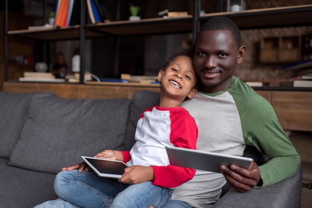 Afro-Amerikaanse vader en gelukkige zoon met behulp van digitale tablets