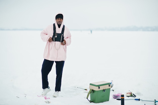 Afro-Amerikaanse visser op bevroren zee. Wintervissen.