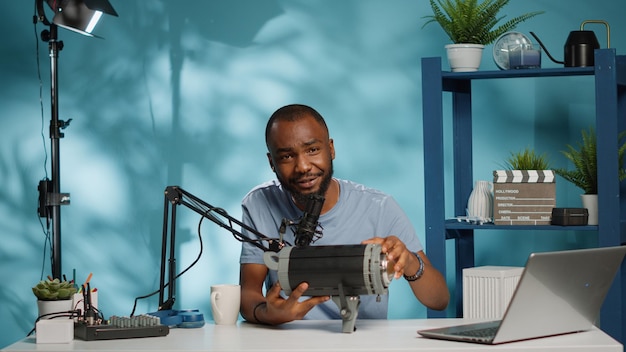 Afro-Amerikaanse vlogger doet productbeoordeling van studiolicht voor videografie op camera. POV van zwarte influencer die praat over uitrusting en uitrusting voor aanbeveling op podcast.