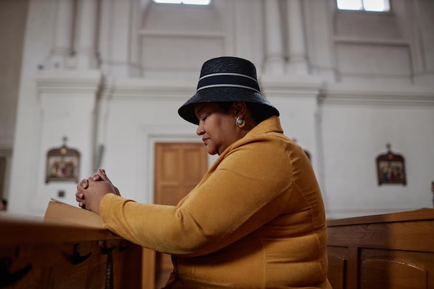 Afro-Amerikaanse vrouw bidden in de kerk