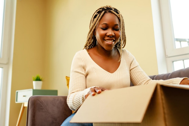 Afro-Amerikaanse vrouw die dingen in een doos verpakt om te verhuizen