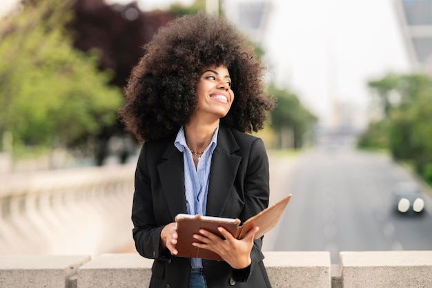 Afro-Amerikaanse vrouw die een boek leest in de stad digitaal boek concept