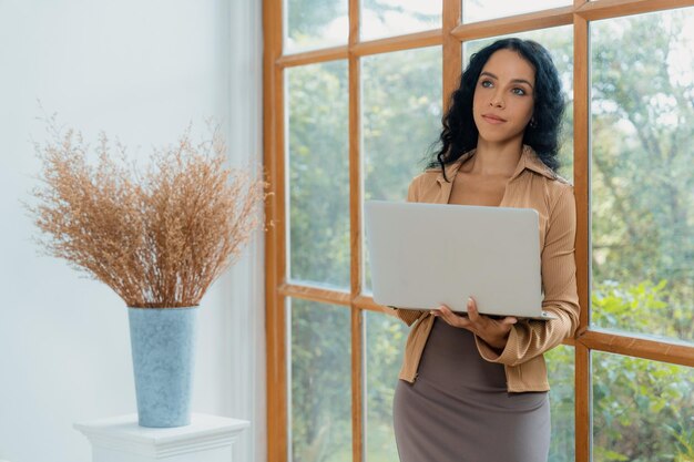 Afro-Amerikaanse vrouw die een laptopcomputer gebruikt voor cruciaal werk op internet, secretaris of online inhoud schrijft terwijl ze thuis werkt