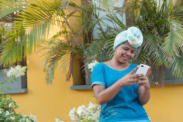 Afro-Amerikaanse vrouw die haar mobiele telefoon controleert