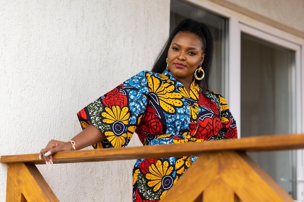 Afro-Amerikaanse vrouw die ontspant en geniet van de zon terwijl ze op het terras of balkon staat bij zonlicht