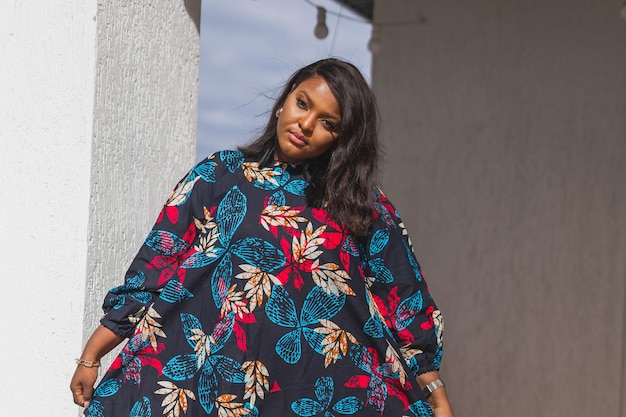 Afro-Amerikaanse vrouw die ontspant en geniet van de zon terwijl ze op het terras of balkon staat bij zonlicht